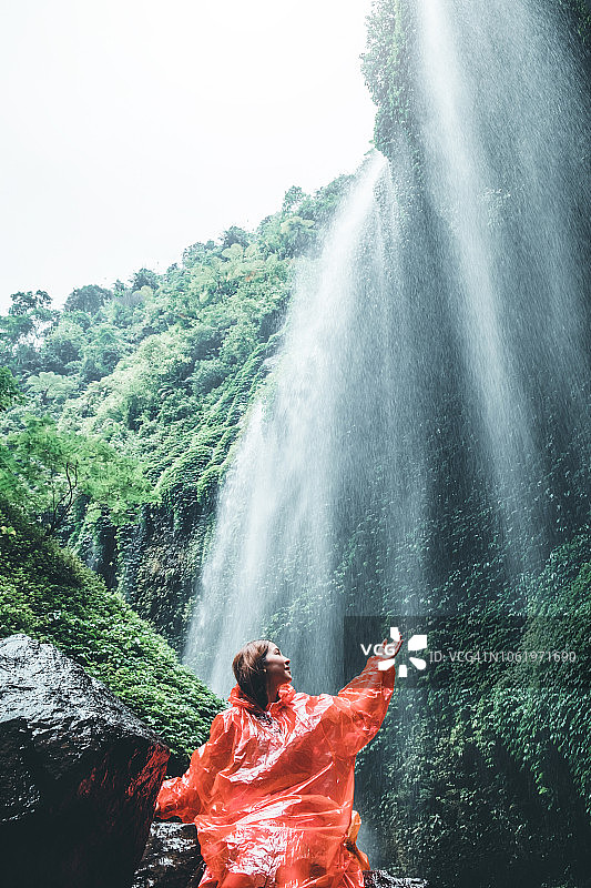 妇女站在马达卡里普拉瀑布附近，东爪哇，印度尼西亚图片素材