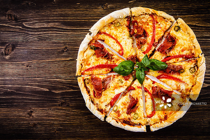 玛格丽塔披萨，火腿和胡椒，木质背景图片素材