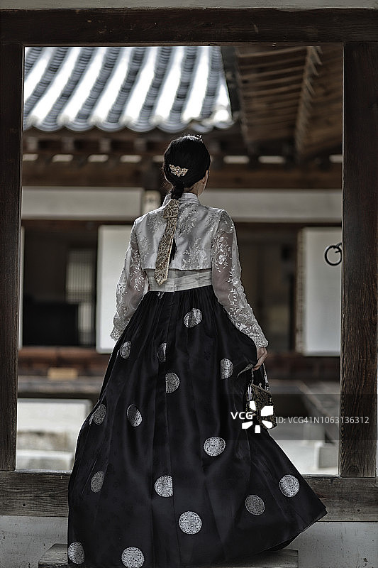 身着韩服的女子走进传统的韩国家庭图片素材