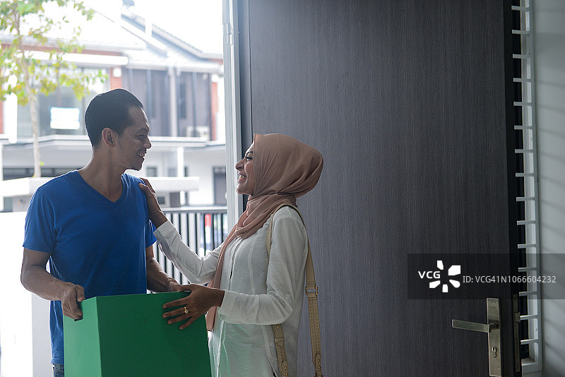 快乐的年轻亚洲穆斯林夫妇搬进他们的新家在吉隆坡，马来西亚图片素材
