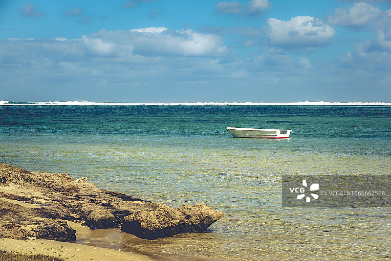 一艘小船停靠在非洲毛里求斯岛的热带海滩上。图片素材