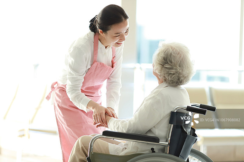 护工和坐轮椅的老妇人聊天图片素材