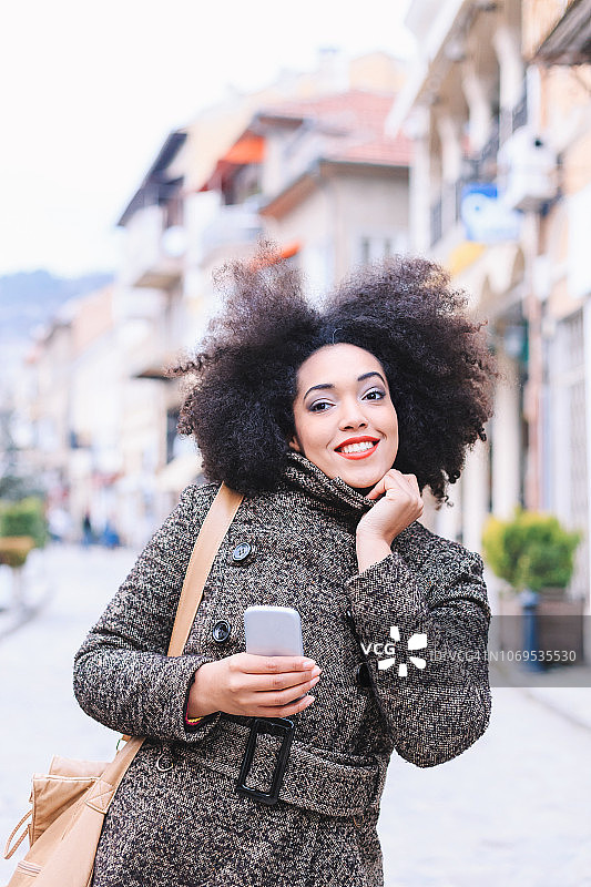 身着秋装的非洲女人微笑着走在大街上图片素材