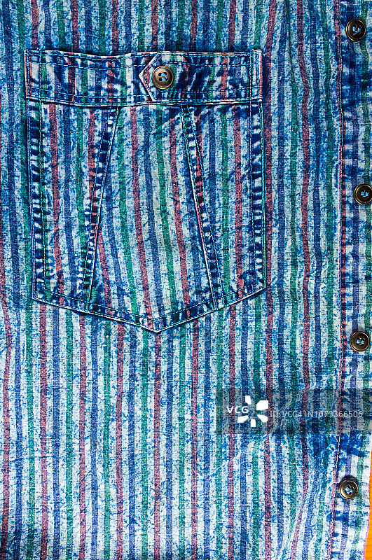 蓝色水洗褪色的条纹牛仔裤，有接缝，扣子，纽扣和铆钉图片素材
