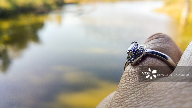 靠近白人妇女手与订婚戒指在水边，克鲁格国家公园，南非图片素材