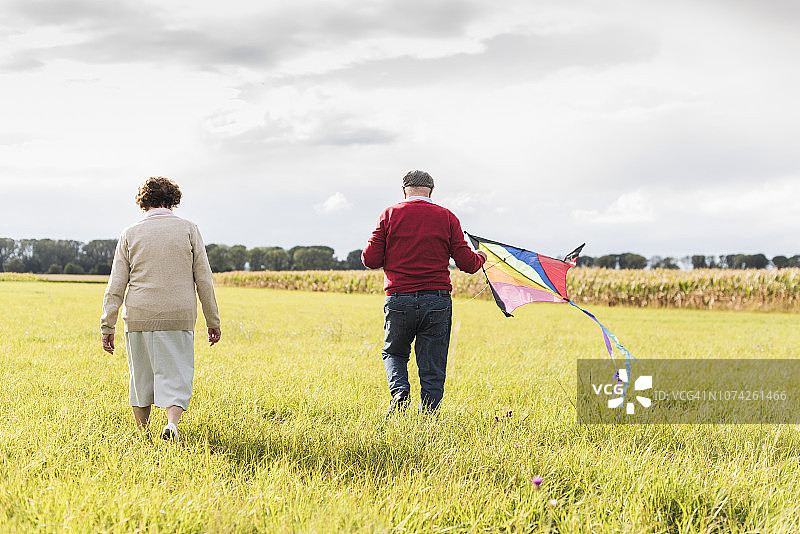一对老年夫妇带着风筝在乡间散步图片素材