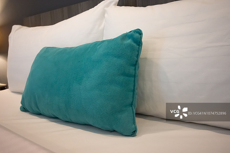 舒适的卧室里，白色的枕头放在床上图片素材
