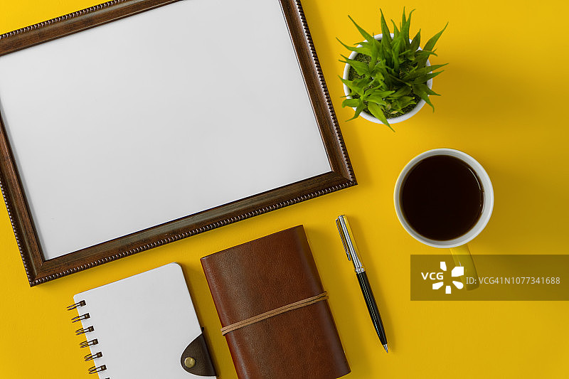 空木画框，笔记本和咖啡在黄色的背景图片素材