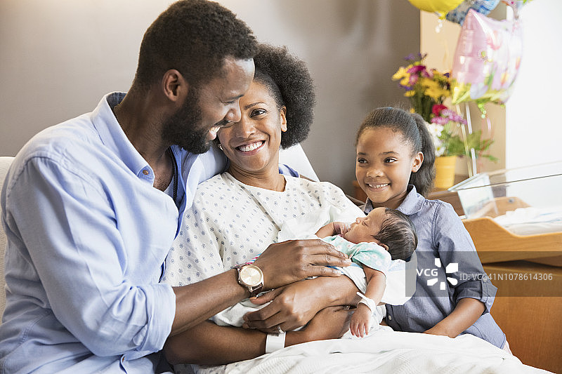 非裔美国家庭在病房里欣赏他们的新生儿图片素材