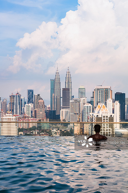 马来西亚，一名男子在吉隆坡的无边泳池里图片素材
