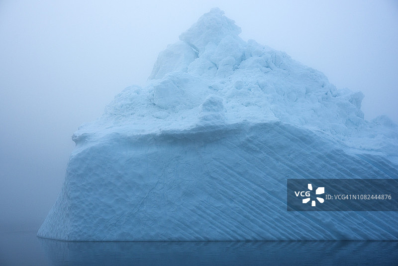 在一个有雾的日子里，北冰洋上的冰山图片素材