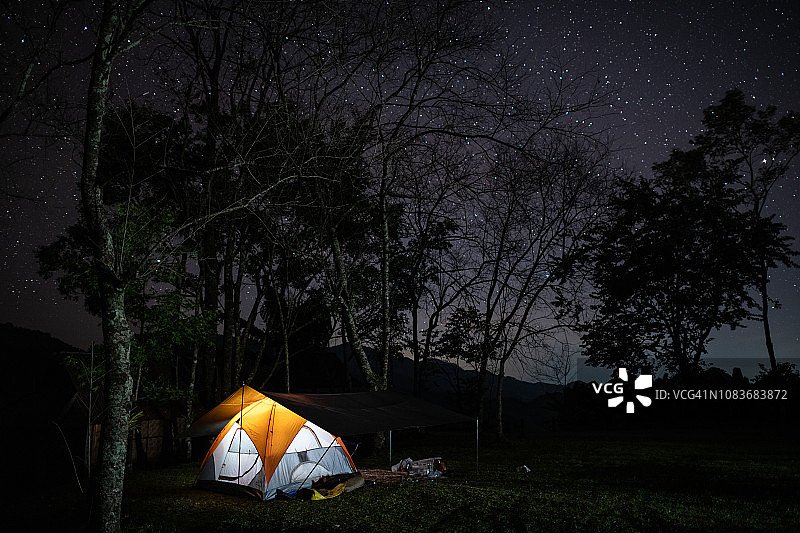 在泰国南Doi Phu Kha的野外露营。长曝光拍摄的一个露营帐篷在夜晚与星星的痕迹在夜空图片素材