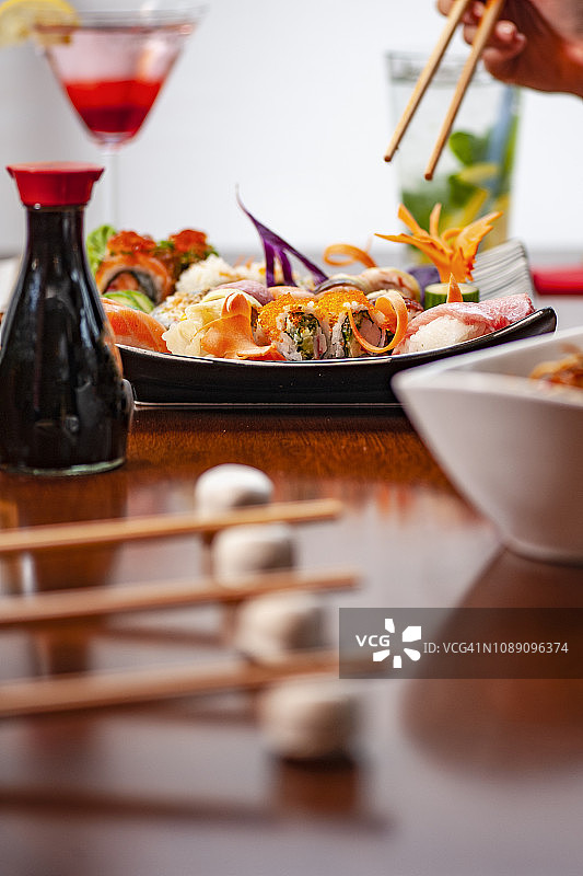 寿司店餐桌上的一套寿司、酱油和红酒图片素材