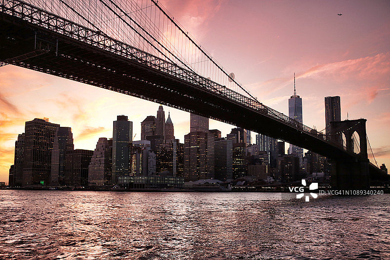 日落时分从小飞象河岸上看到的曼哈顿和布鲁克林大桥的天际线。美国纽约市图片素材