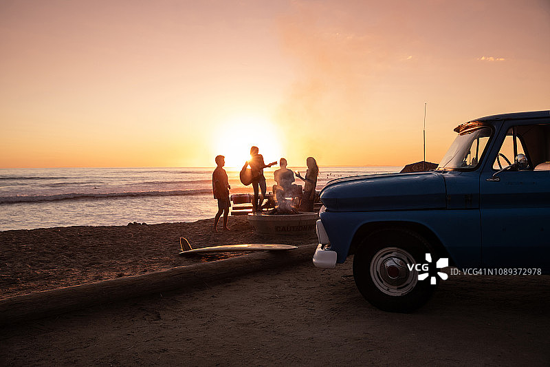 日落时分在加州海滩上的家庭聚会图片素材