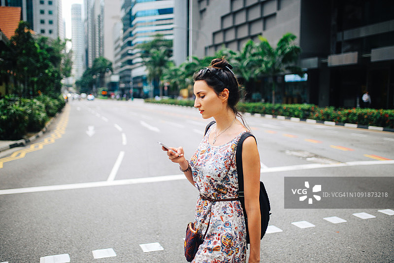 年轻时尚的新加坡女游客在手机上查看应用程序图片素材