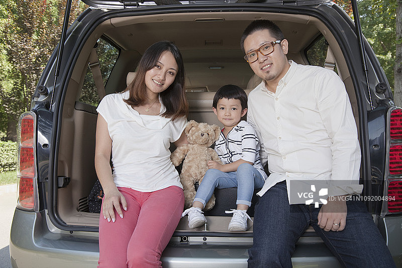 一个中国家庭坐在汽车后备箱里图片素材