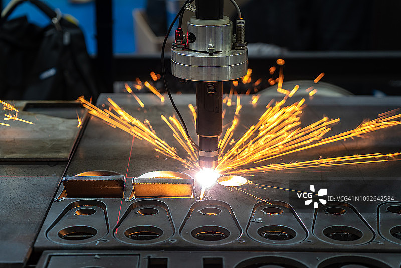 光纤激光切割机用火花光切割金属板材。高新技术制造业的概念。图片素材