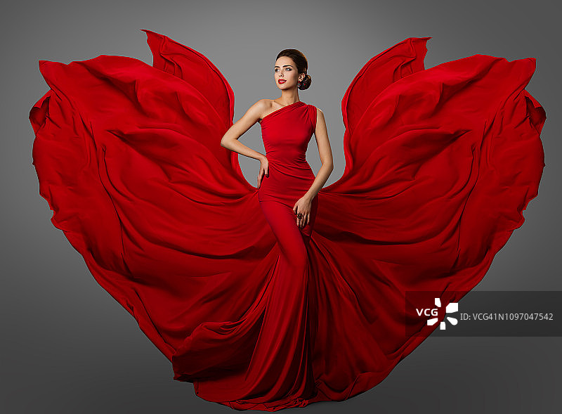 女人红色连衣裙，时装模特在长丝绸摆动长袍翅膀，飞扬飘扬的织物图片素材