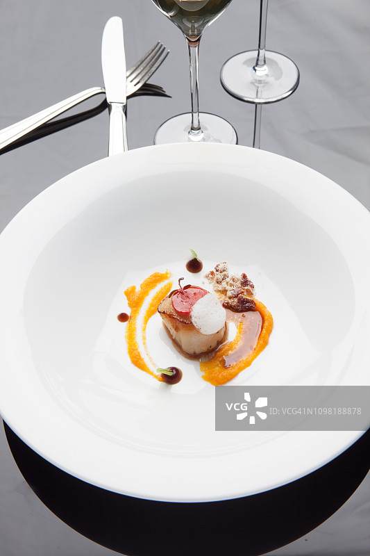 法式鲜扇贝在精致餐桌上烹饪图片素材