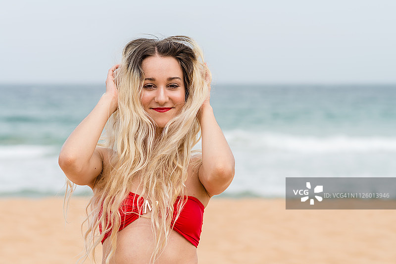 在澳大利亚悉尼的海滩上穿着红色比基尼的女人图片素材