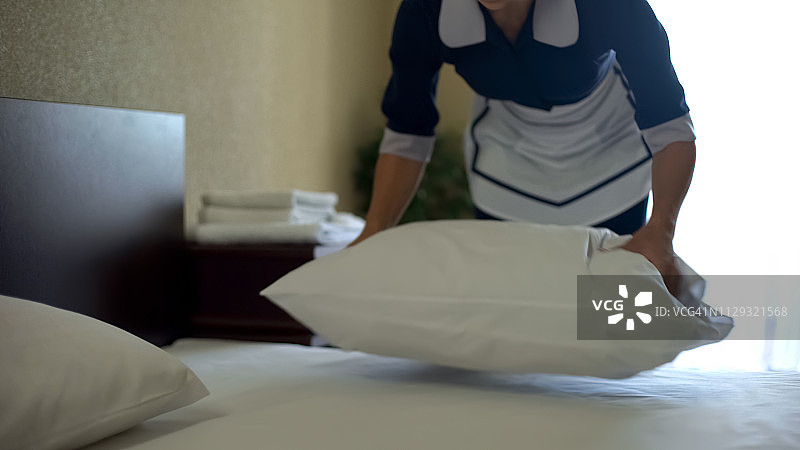 酒店工作人员用香粉洗完床单后把枕头弄松图片素材