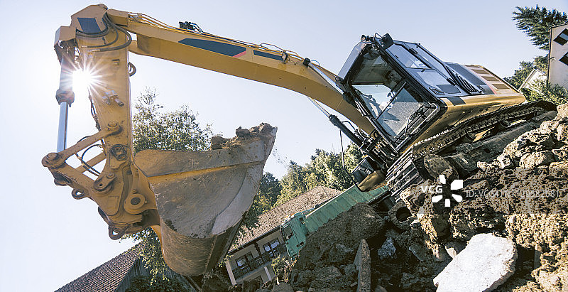 挖掘机在建筑工地抓取泥土和碎片图片素材