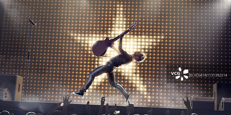 摇滚明星在半空中跳跃与吉他在舞台上图片素材