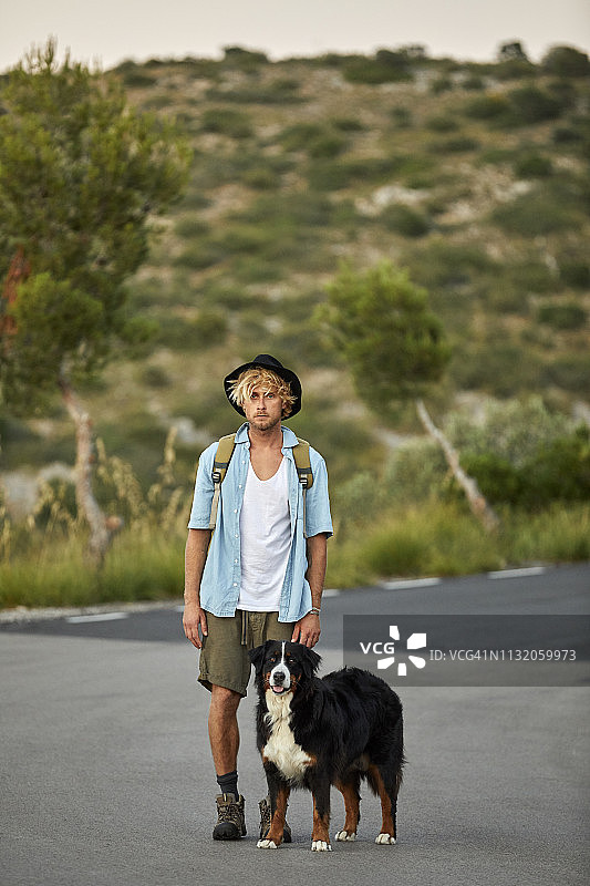 徒步旅行者和狗站在路上图片素材