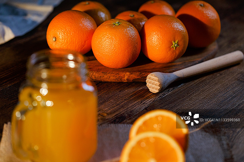 在粗糙的木桌上拍摄的橙汁玻璃罐图片素材