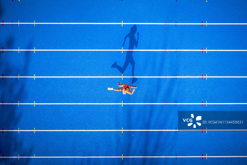 俯视图的女跑步者在格子跑道图片素材