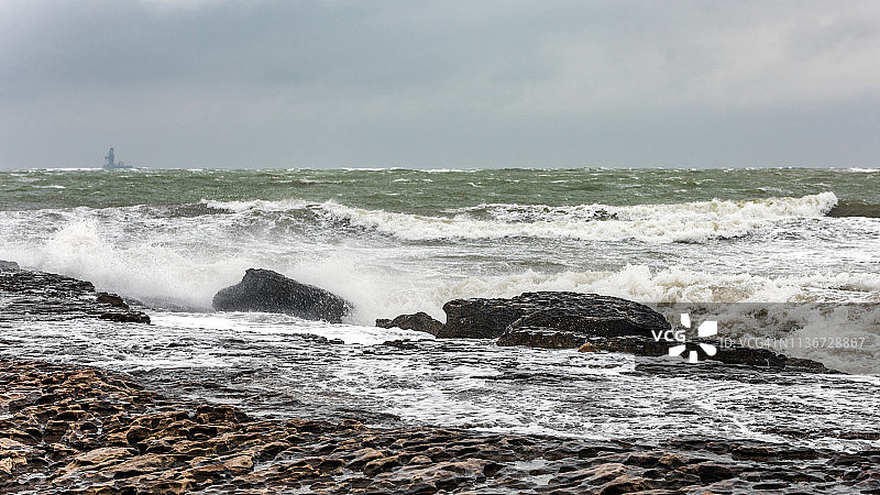 巨浪拍打多岩石的海岸图片素材