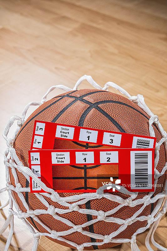 一对冠军篮球票旁边的球与竞技场木地板的背景图片素材