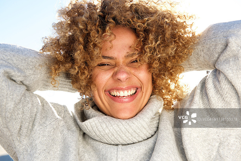 近距离观察快乐的非洲裔美国妇女笑着双手在脑后图片素材