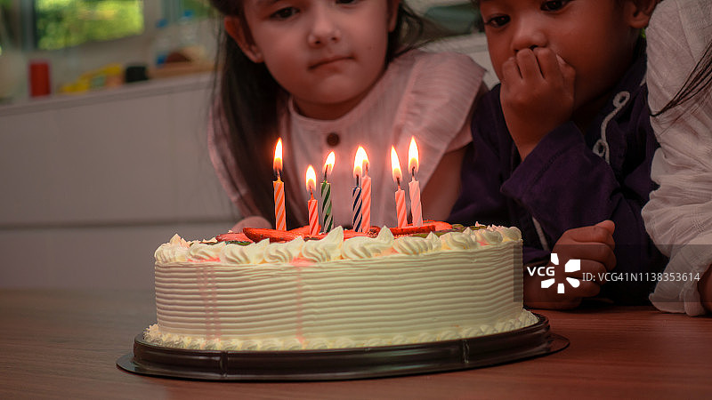生日庆祝，小朋友在吹蜡烛，小朋友在吹HBD蛋糕图片素材