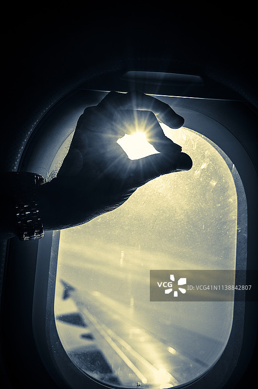 在飞机窗户的阳光下，用手做出ok的手势图片素材