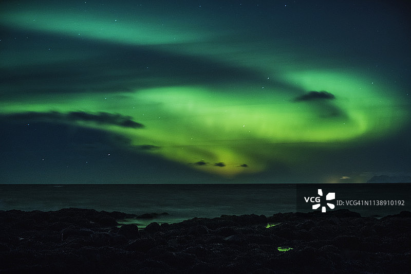 冰岛雷克雅斯贝尔海面上的神秘北极光图片素材