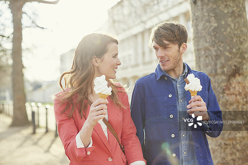 英国伦敦，一对情侣在街上散步时吃着甜筒冰淇淋图片素材
