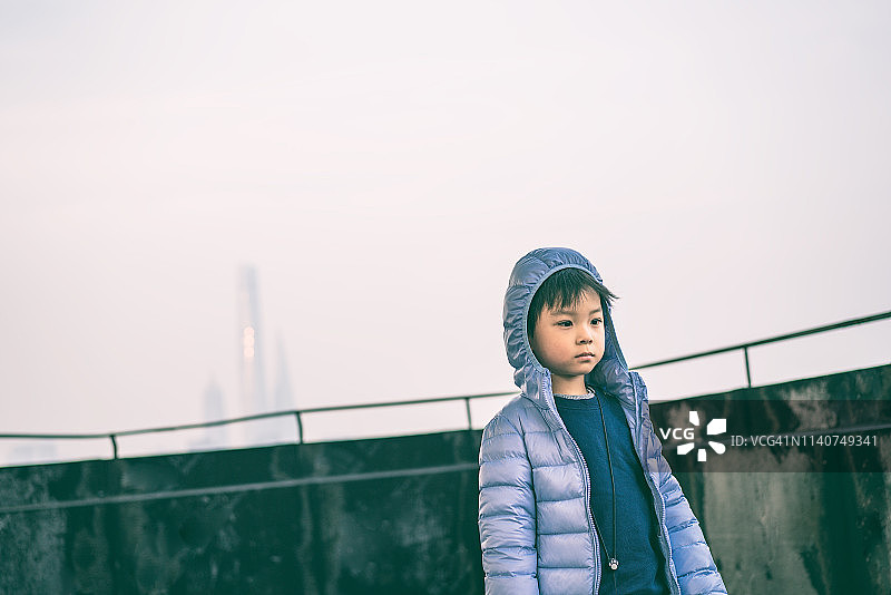 一个小男孩在中国上海高楼的屋顶上的肖像图片素材