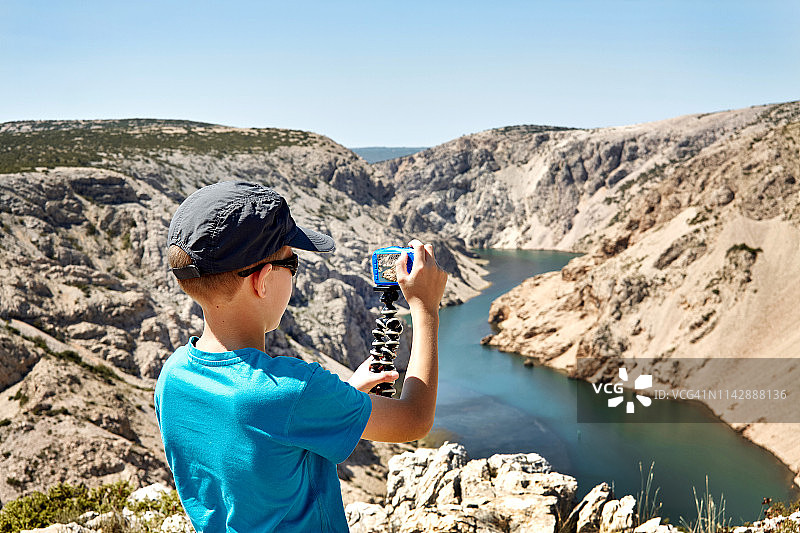 克罗地亚，男孩在拍摄兹曼尼亚河峡谷的照片。图片素材