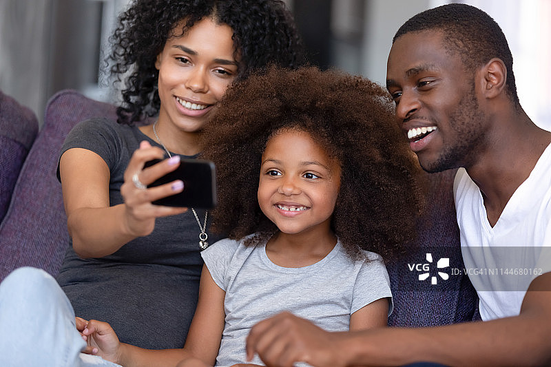 欢乐的非洲家庭和孩子用手机自拍图片素材