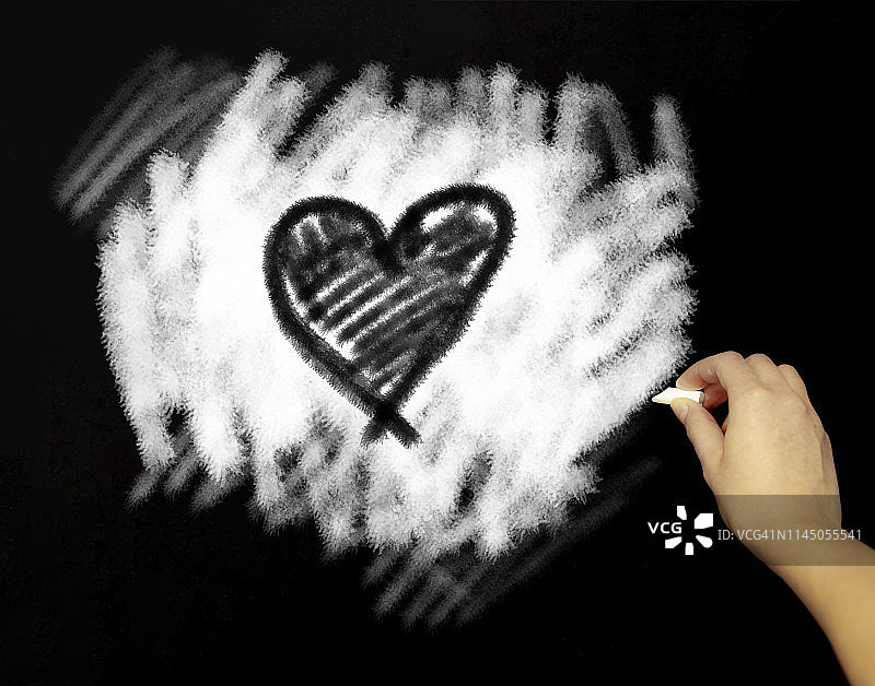用粉笔在黑板上亲手画一颗心图片素材