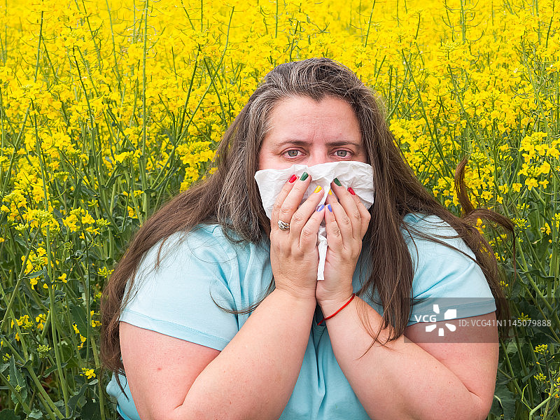 一个对花粉过敏的女人打喷嚏的肖像图片素材
