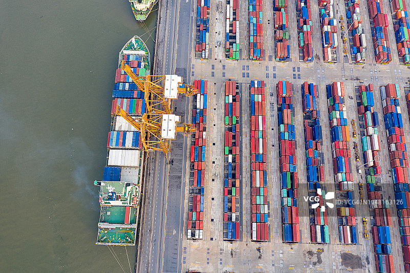 俯视国际港口用起重机装载集装箱的进出口物流业务图片素材