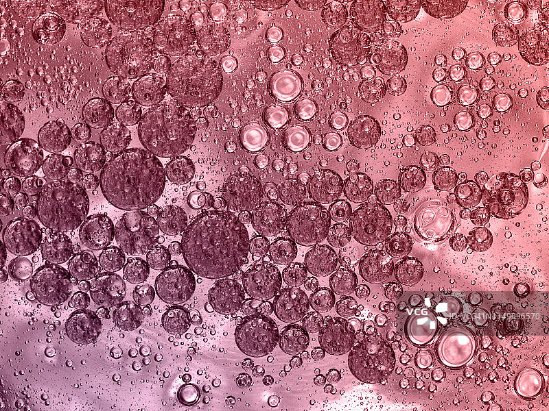 全框架的抽象形状和纹理，形成的泡沫和液滴在粉红色的液体背景。图片素材