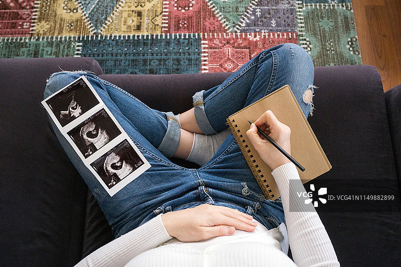 孕妇用超声波图像给宝宝写纸条图片素材
