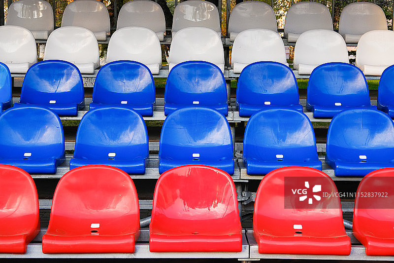红色，蓝色和白色的体育场座位。看台空无一人，没有观众。图片素材
