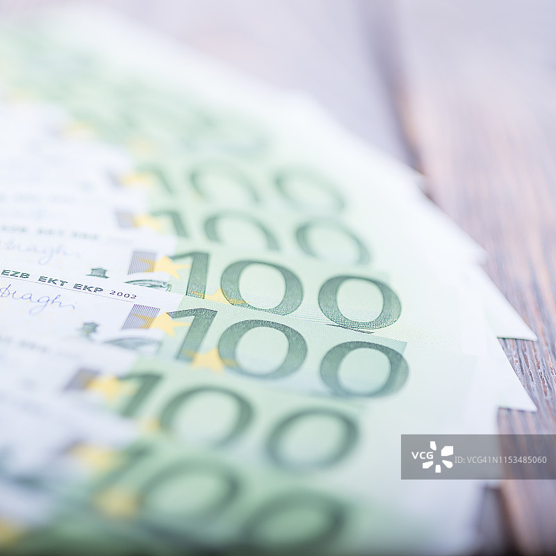 黑色木制背景上的欧元现金钞票。图片素材