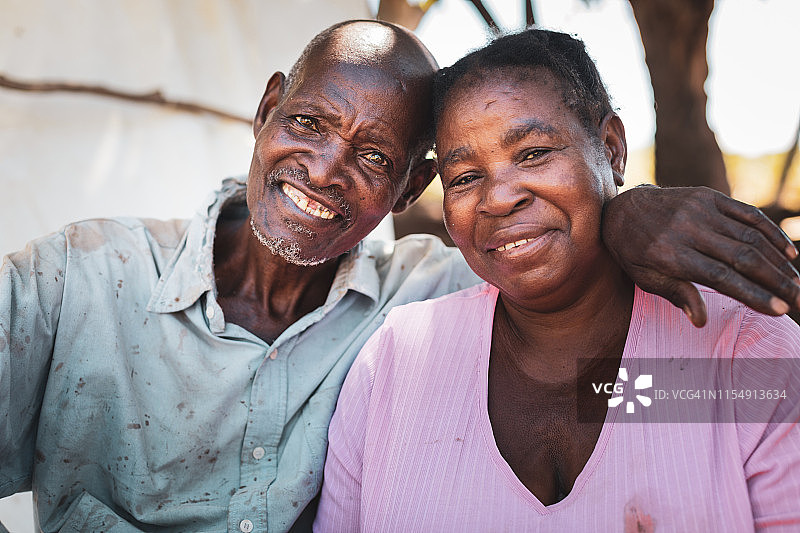 坐在村庄小屋附近的非洲老年夫妇的肖像图片素材