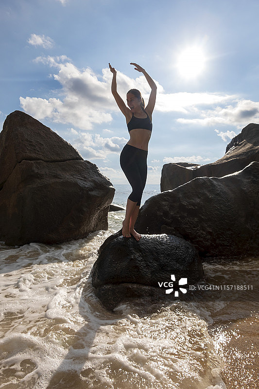 塞舌尔，马埃，塔卡马卡海滩，一个成熟的女人在背光下站在岩石上图片素材